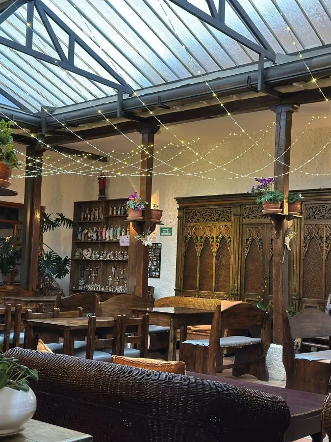 Salón principal de EUFORIA bajo el techo de vidrio, con guirnaldas de luces y muebles de madera tallada